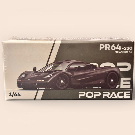 Boxed model car of a McLaren F1 with 'Pop Race' branding on a white background